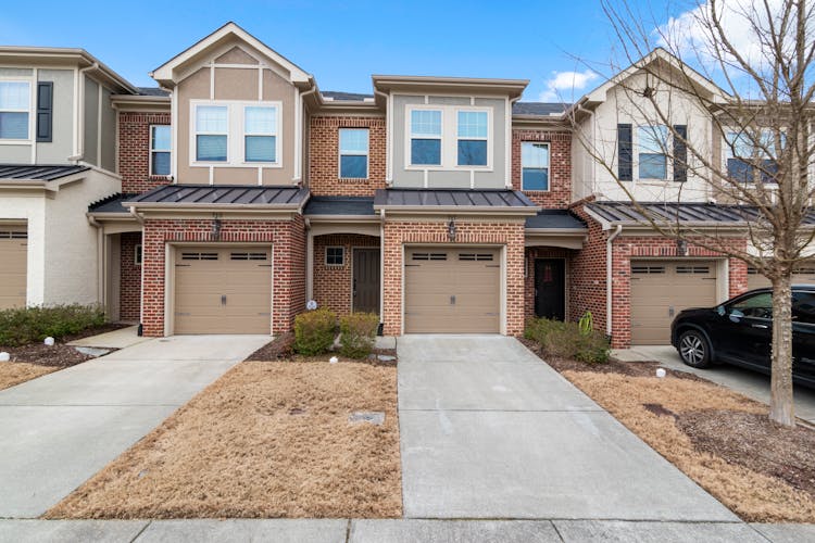 A Brick Adjacent Houses With Brown Garage Doors