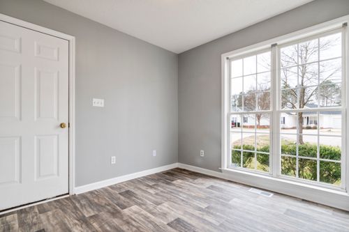 Free Bright and spacious empty room with wooden flooring and large window, perfect for residential property listings. Stock Photo