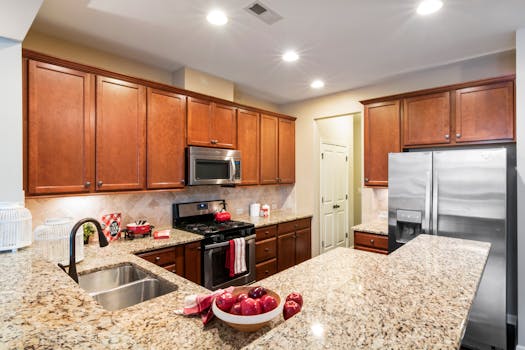 A spacious modern kitchen featuring granite countertops and stainless steel appliances.
