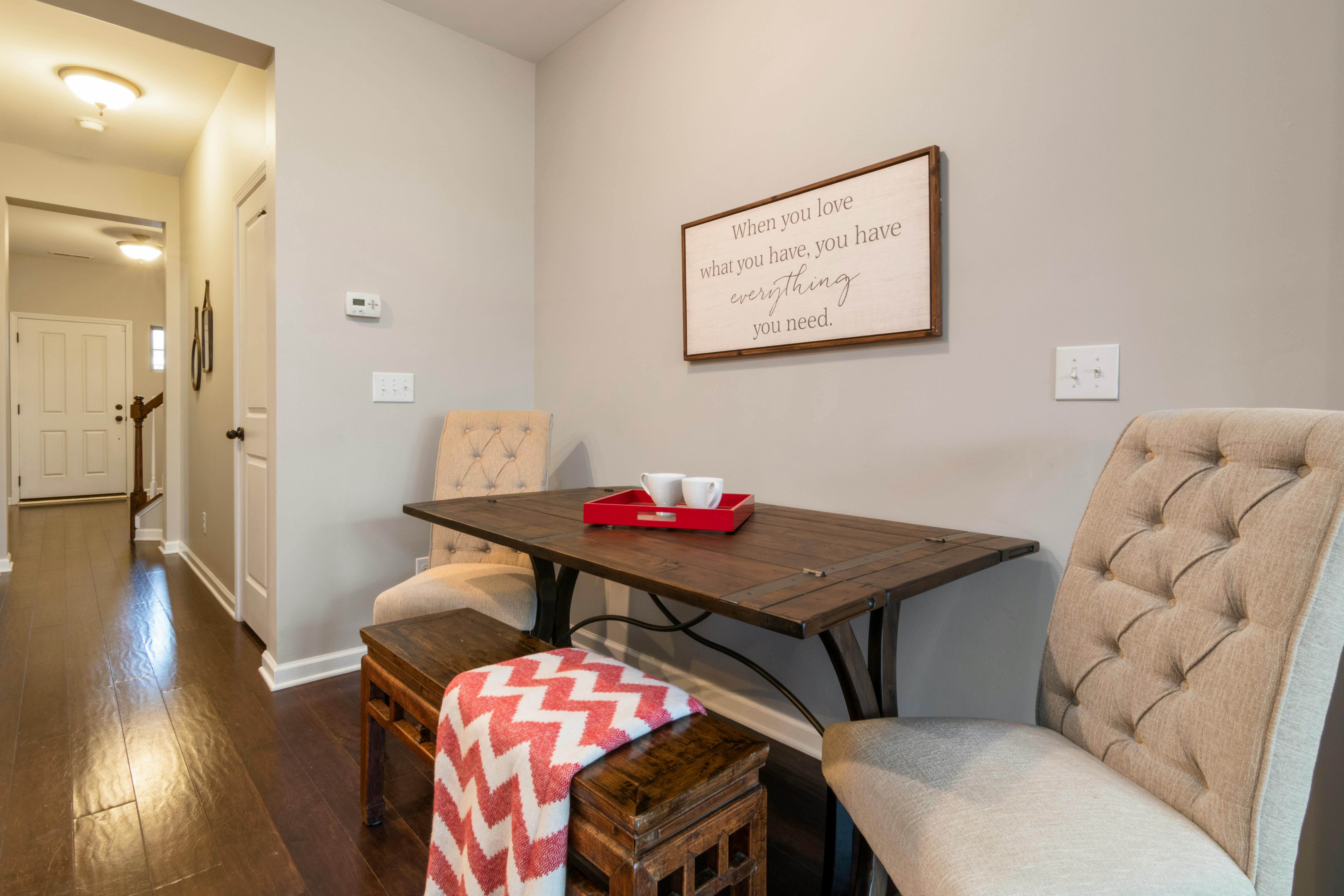 Kleine Essecke mit Wandbank, hellem Holztisch und warmer Pendelleuchte in neutralen Beigetönen