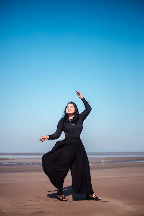 Free 
A Woman Wearing a Black Outfit on a Beach Stock Photo