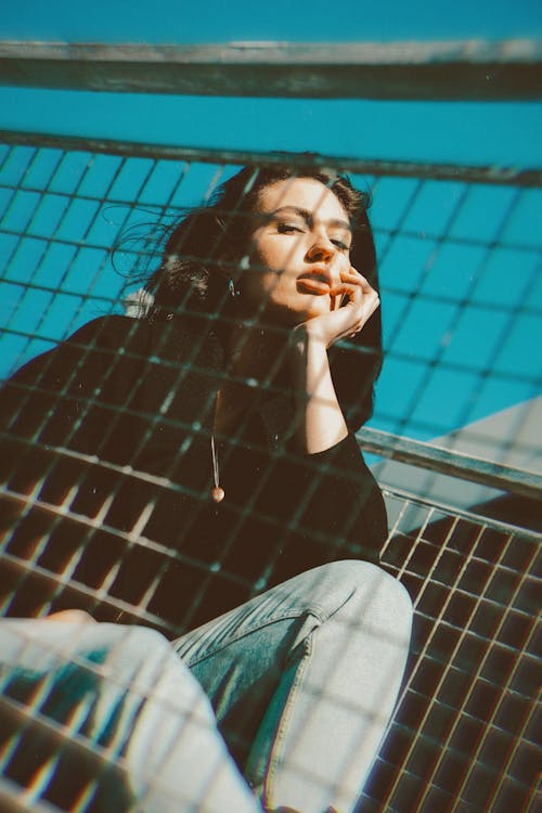 Low-Angle Shot of a Woman Posing with Her Hand on Her Chin