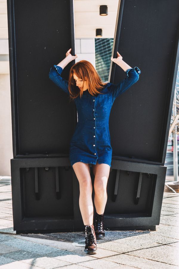 woman in denim midi skirt and black combat boots with an oversized sweater