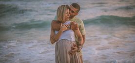 Man in Yellow Polo Shirt Kissing Woman in White Dress on Beach