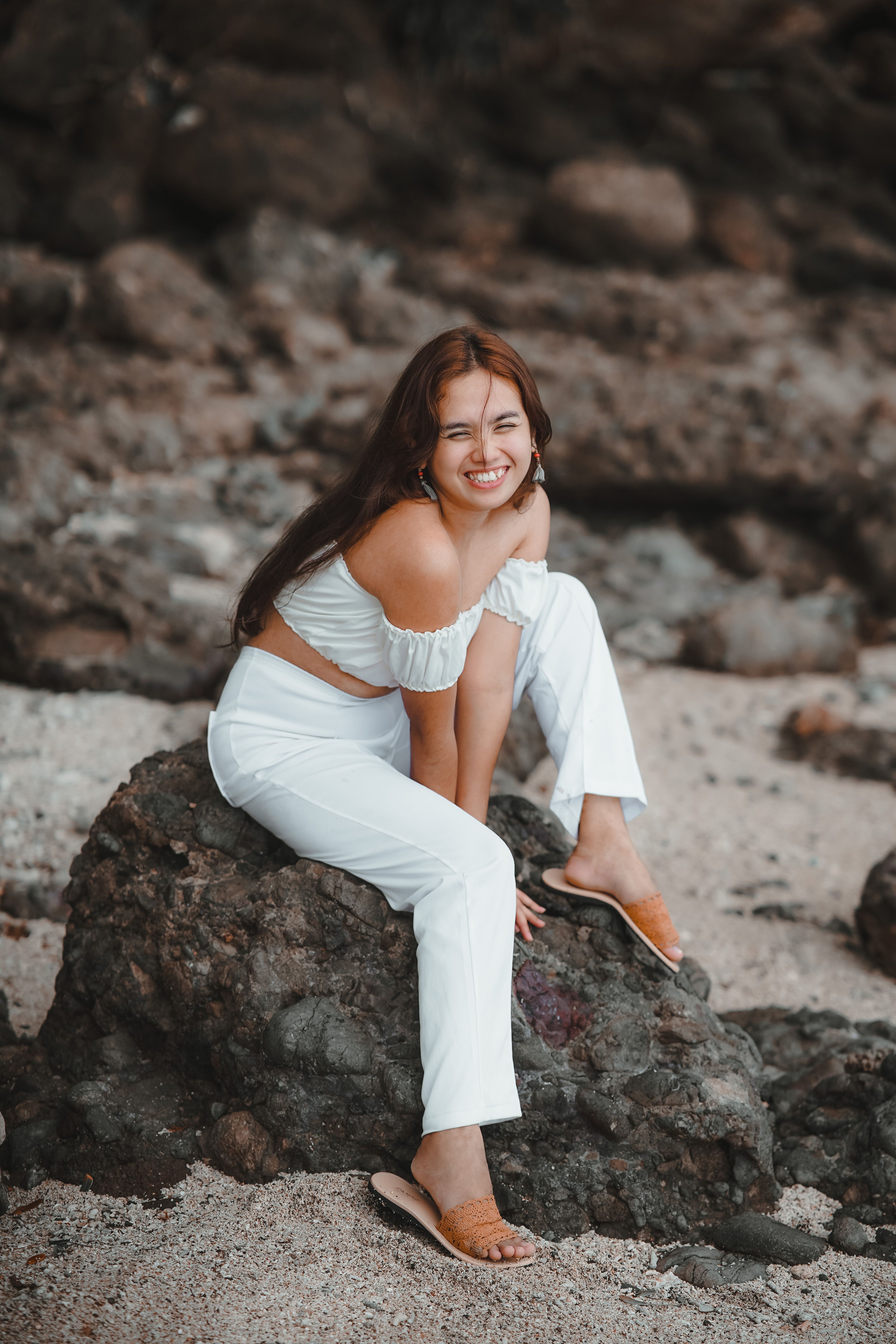Woman in White Clothes Sitting on the Rock in a Beach · Free Stock Photo