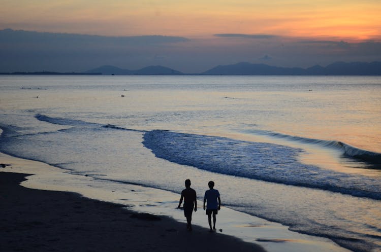 A High Angle Shot Of People Walking Together On The Shore