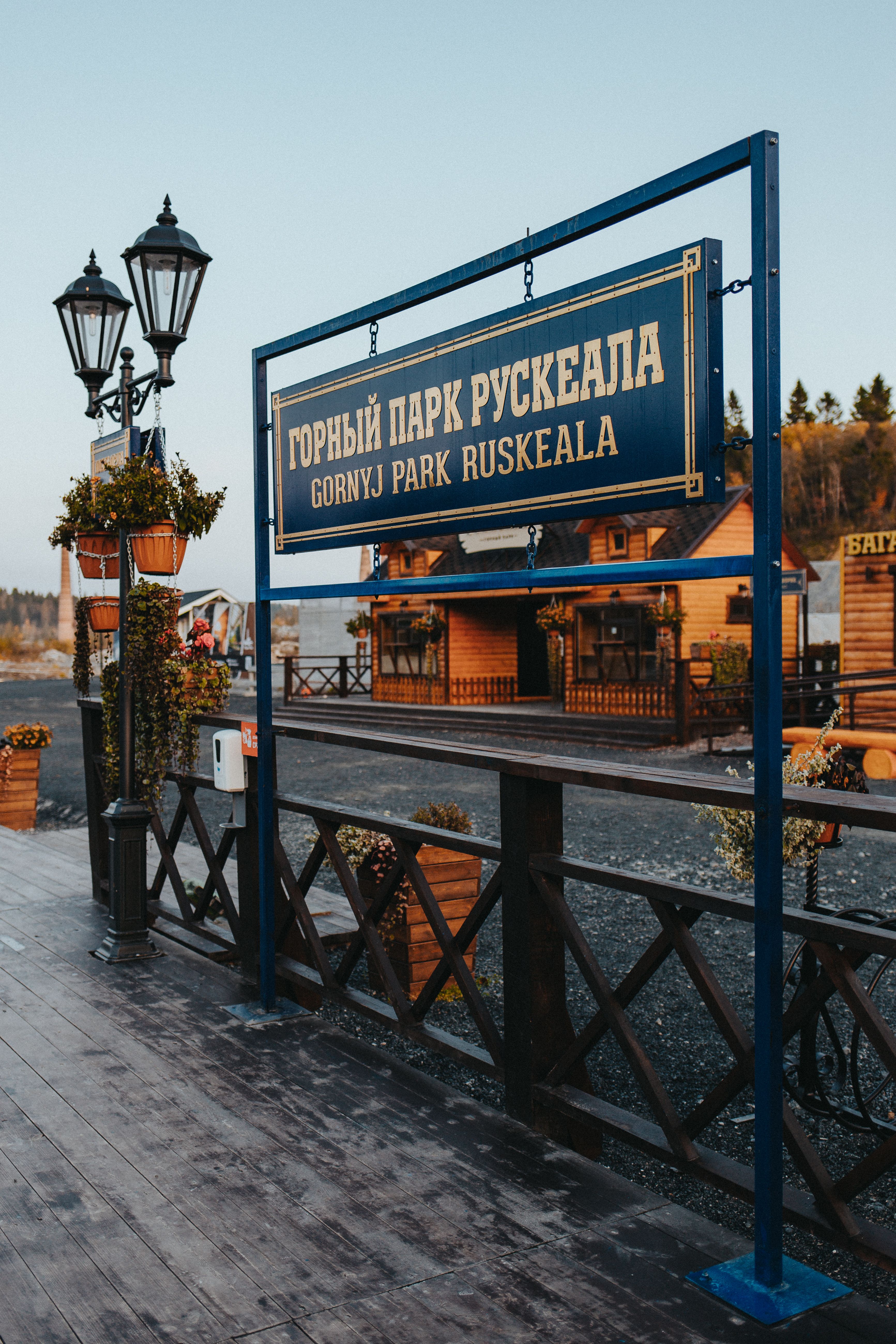 Beautiful entrance to Gorny Park Ruskeala with traditional wooden structures and lanterns.