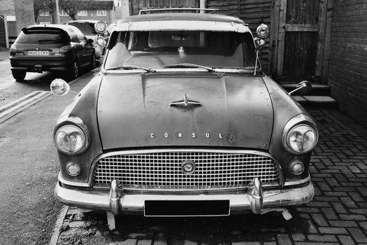A Grayscale Photo of a Classic Car Parked on the Street