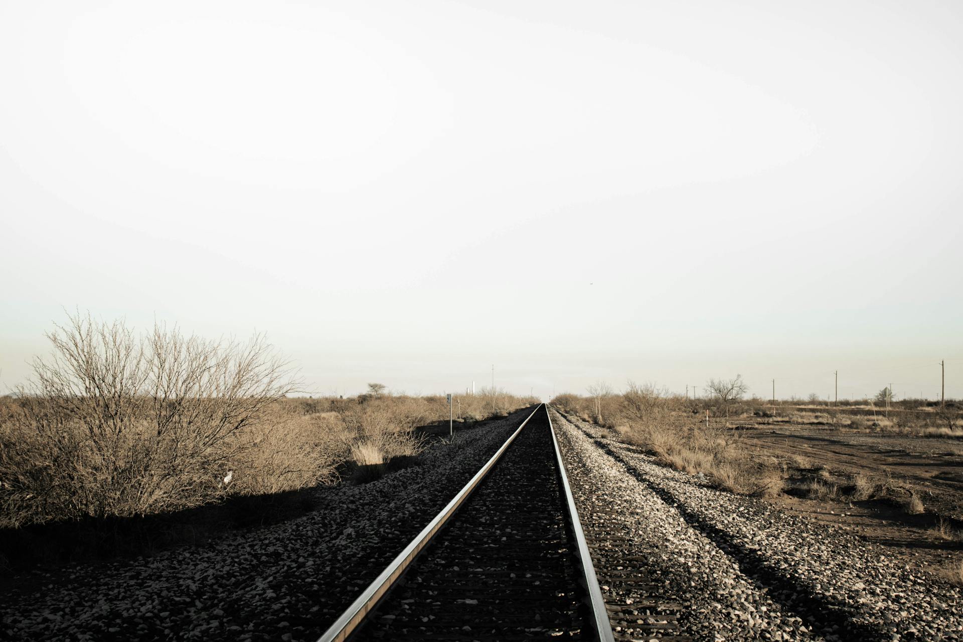 Straight railway tracks cutting through arid Texas landscape near Marfa.
