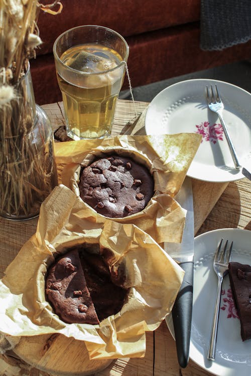 Free Delicious Brownies on a Table with a Glass of Tea and Tableware Stock Photo