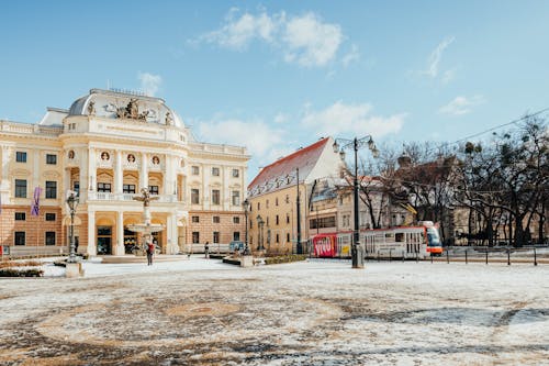 A National Theatre Near the Tram Moving on the Street