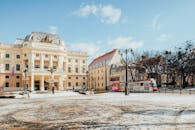 A National Theatre Near the Tram Moving on the Street