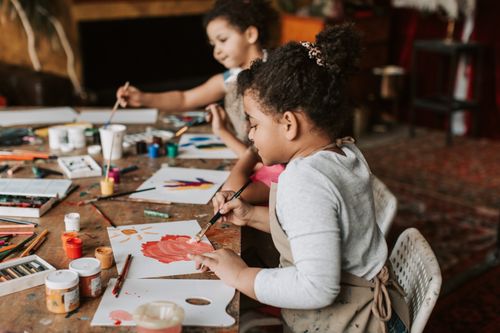 Free Two young children painting with brushes and colors in an indoor art workshop. Stock Photo