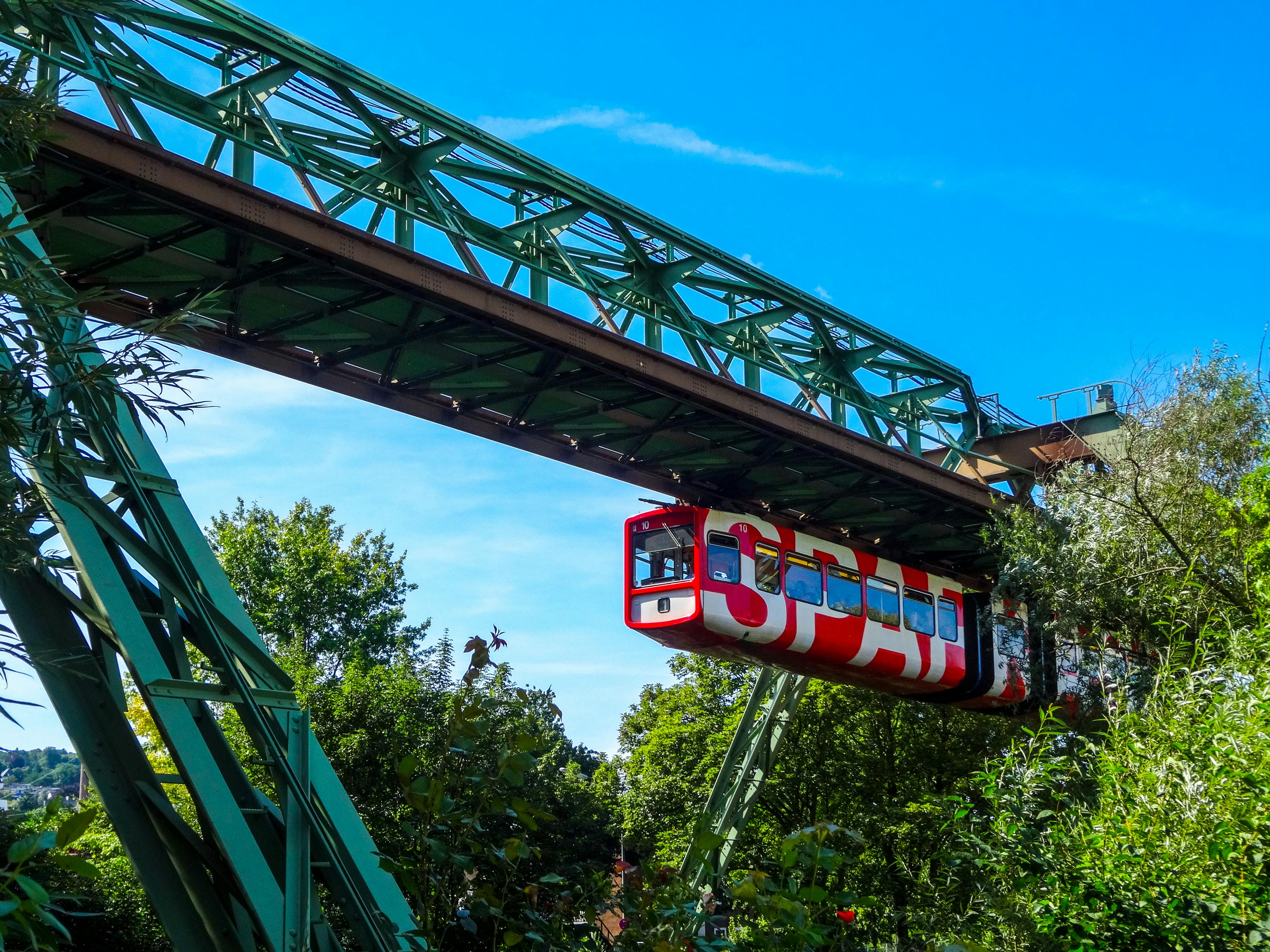 Free Explore the scenic Wuppertal Suspension Railway amidst lush greenery and a clear blue sky. Stock Photo