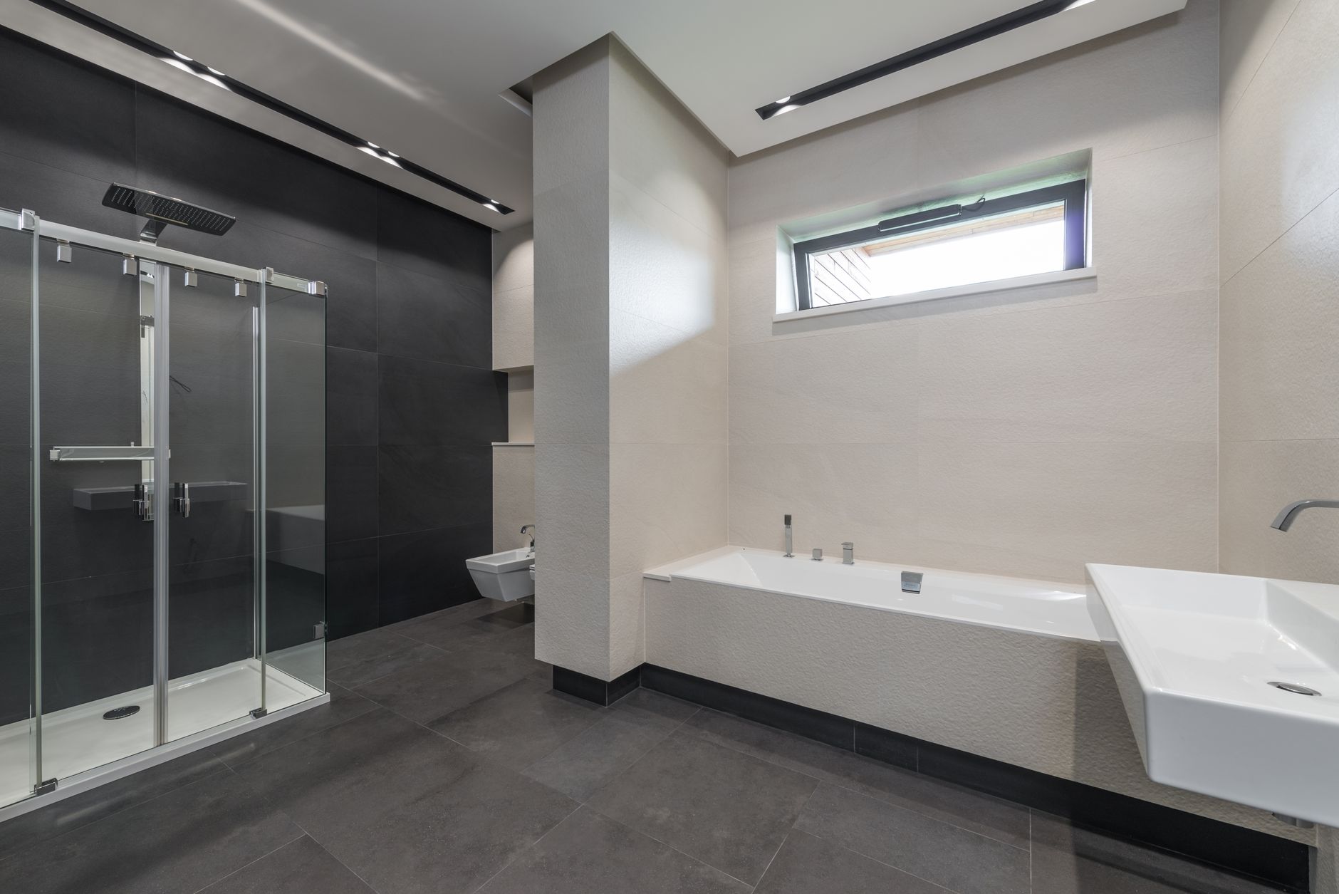 Bathroom Remodeling Trends and Tips for 2025 1 Interior design of contemporary spacious bathroom with shower cabin and bathtub in white and gray tones in modern house