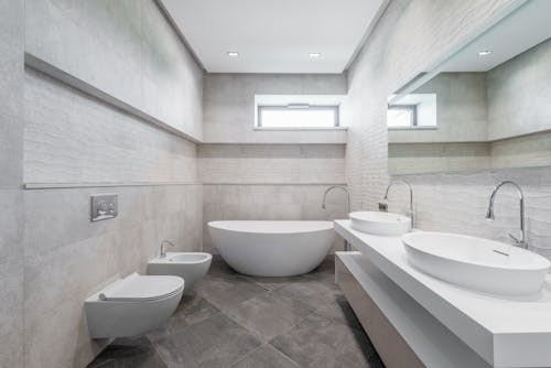 Contemporary light bathroom interior design in minimalist luxury style with double washbasin and bathtub in white and gray tones