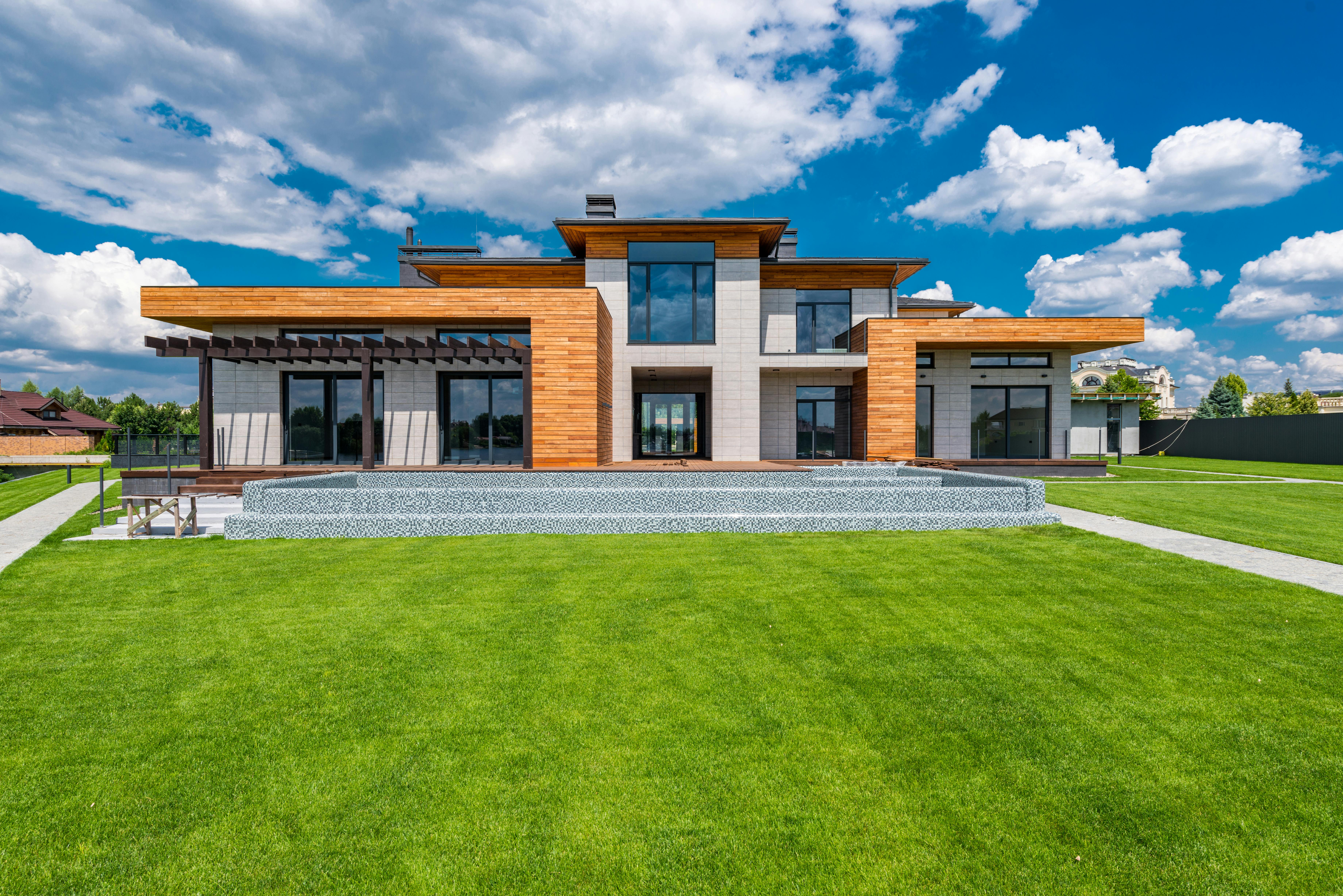 Free Exterior of contemporary building with green grass in yard in daytime under blue sky Stock Photo