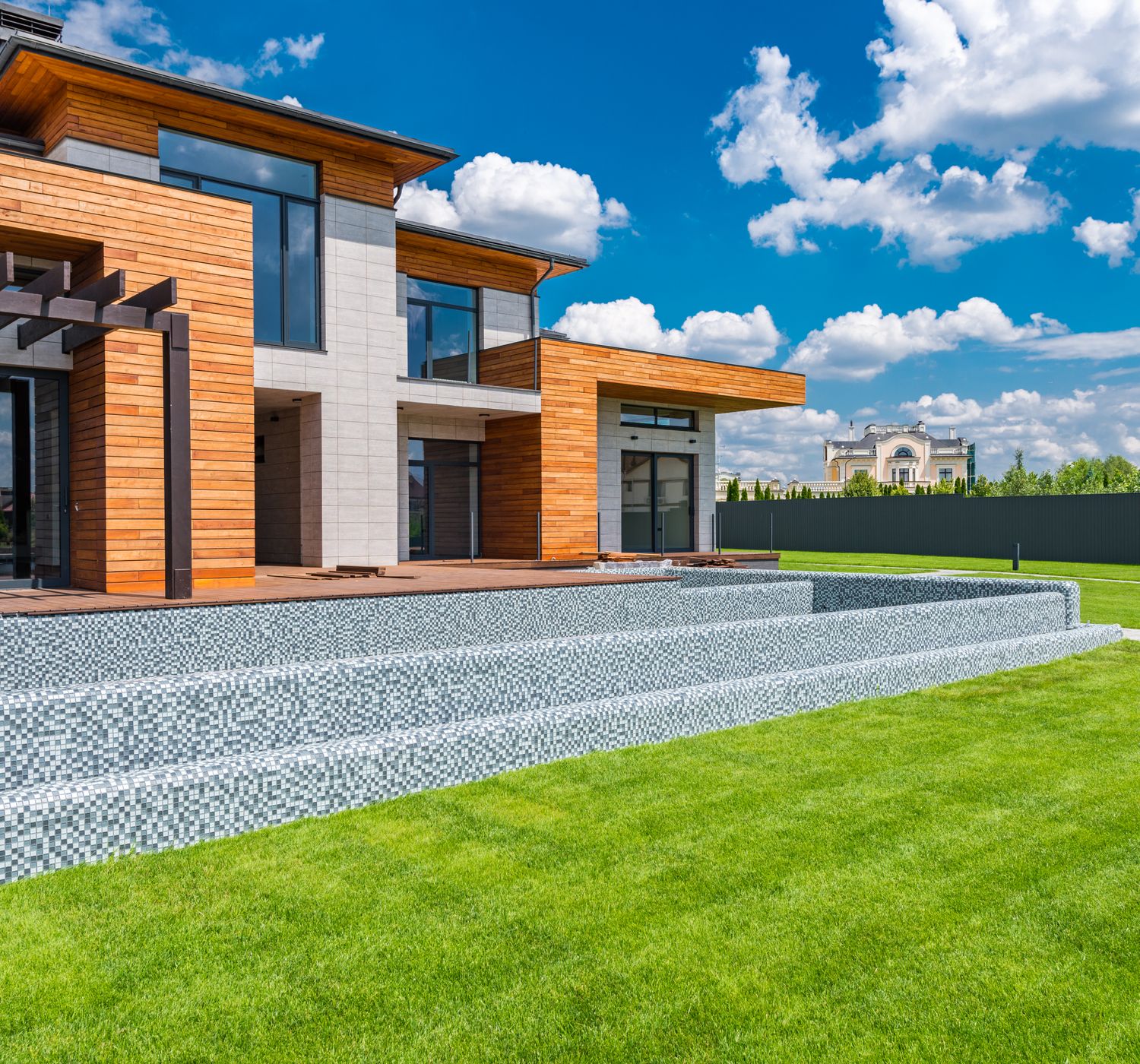 Exterior of contemporary residential house with panoramic windows glass doors and green la