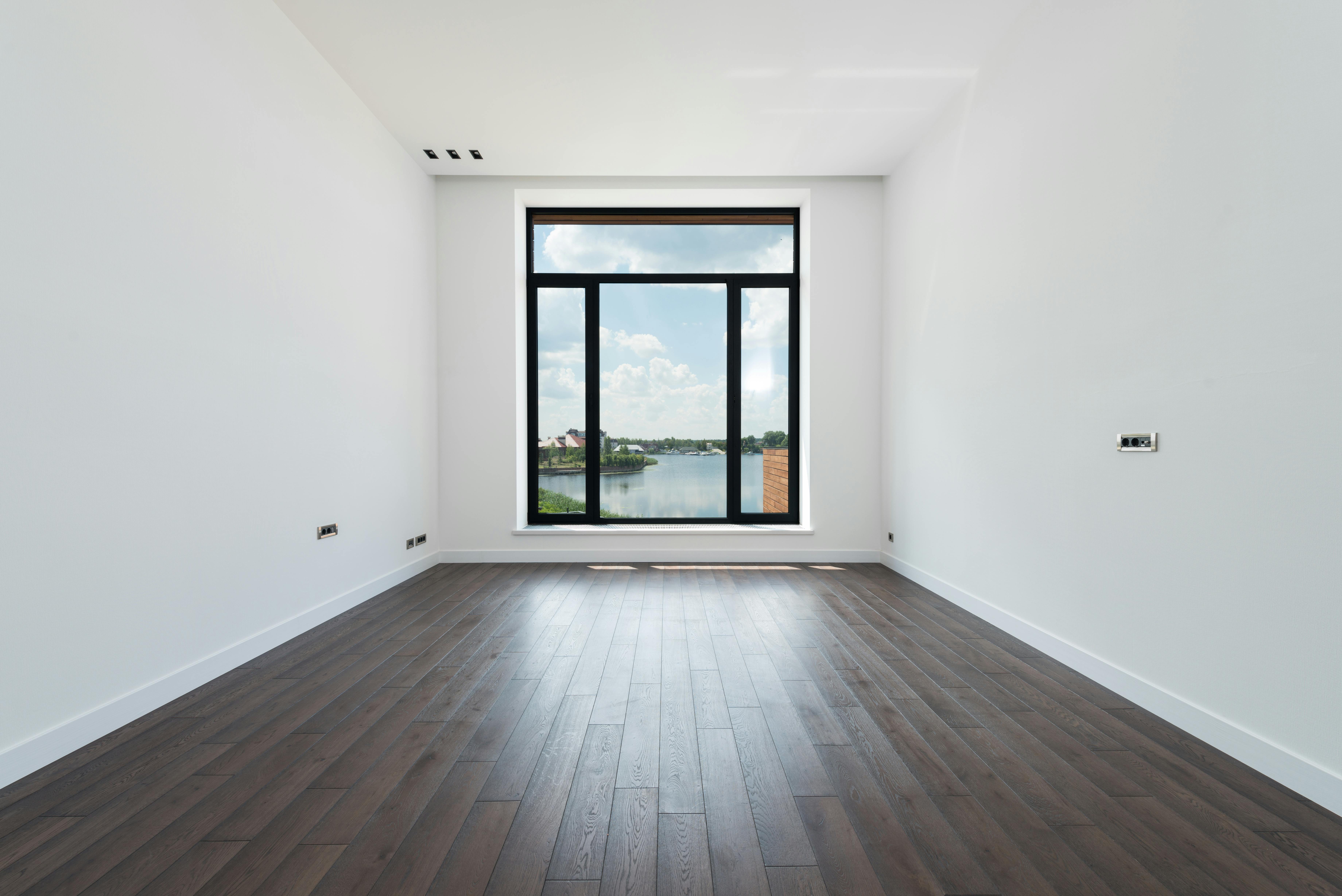 spacious room with white walls and panoramic windows