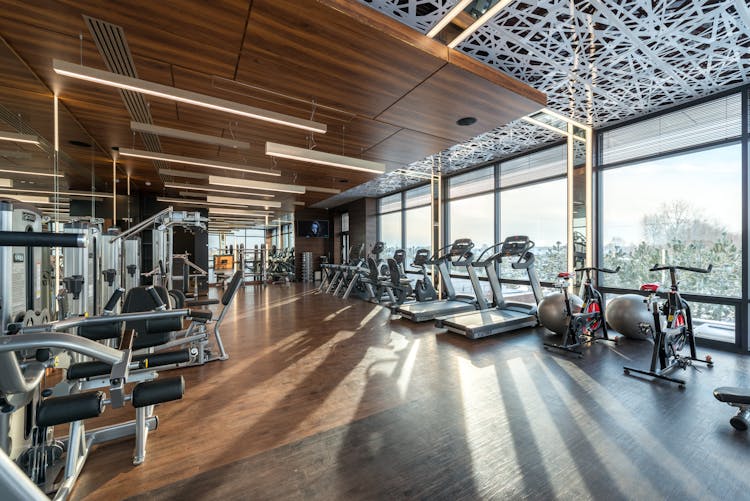 Interior Of Modern Fitness Club With Various Machines And Equipment