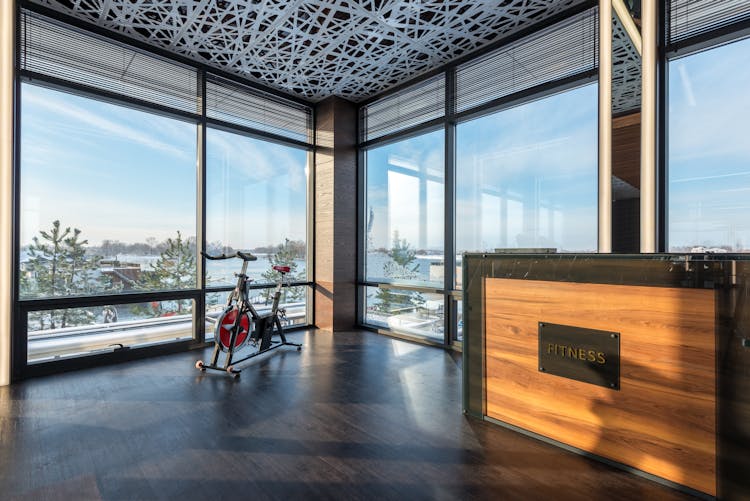 Bike Machine Placed Near Panoramic Windows Of Contemporary Gym