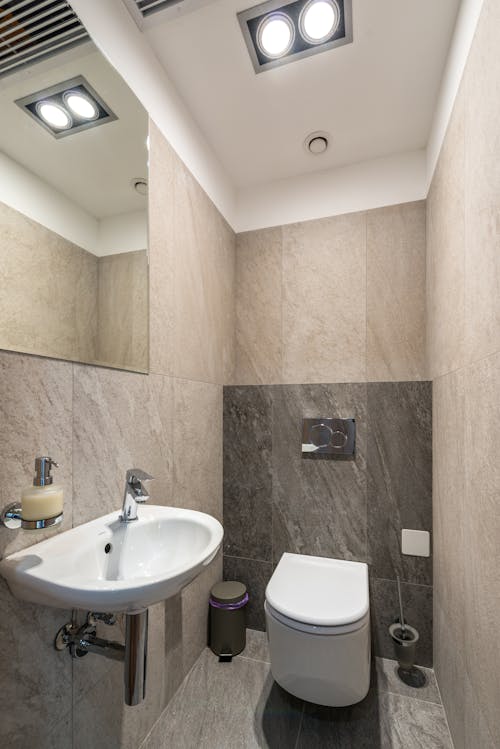 Interior of modern bathroom with ceramic sink and toilet bowl