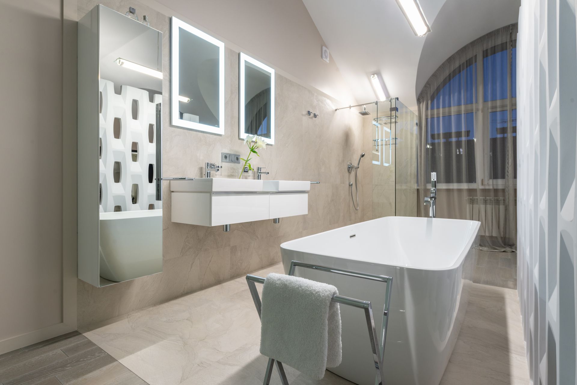 A spacious and elegant modern bathroom featuring a freestanding bathtub and stylish lighting.