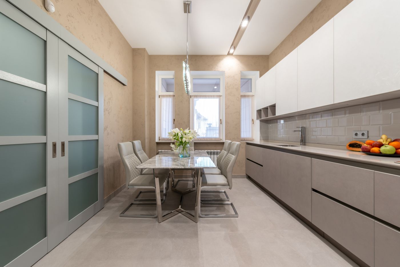 Modern kitchen interior with large windows and glass doors in daylight
