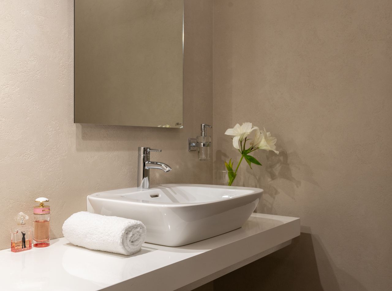 White vessel sink with a mirror and folded towel