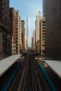 Black and White Train Rail in Between High Rise Buildings