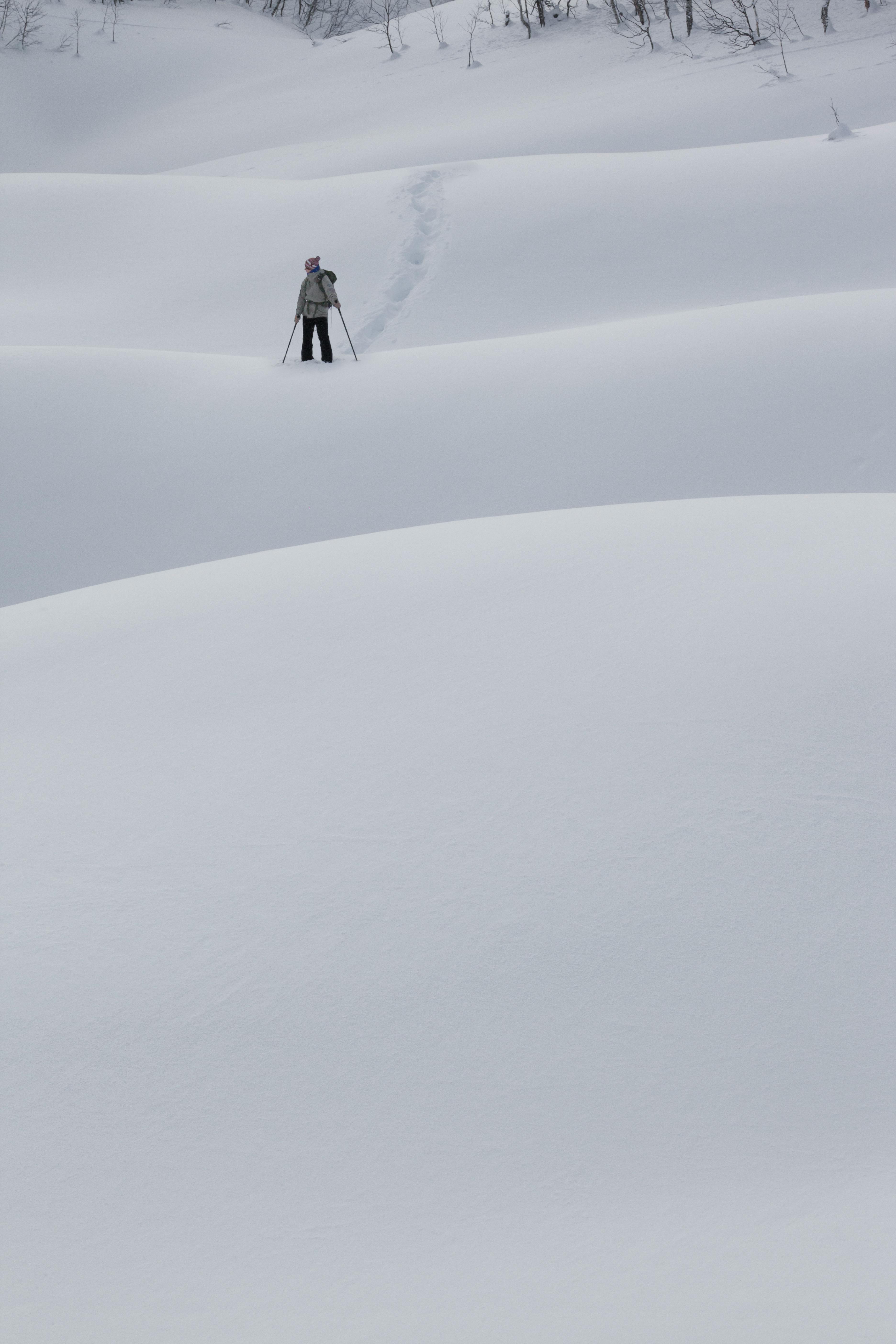 Prescription Goggle Inserts - A lone skier traverses a snowy landscape in Kamchatka, Russia, showcasing winter adventure.