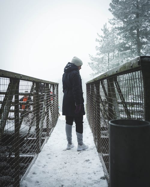 Man in Winter Clothing Standing in a Bridge