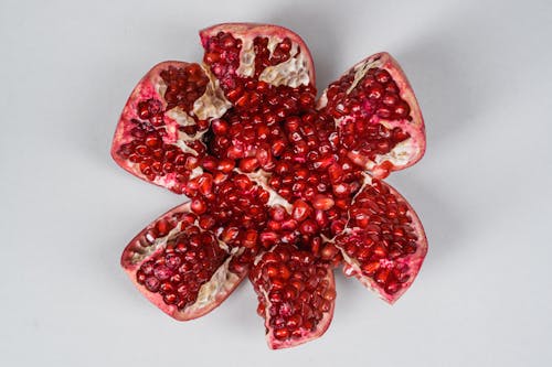 Sliced Pomegranate Fruit on White Surface