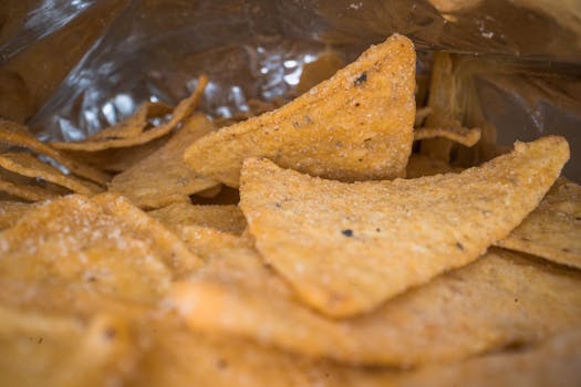 Macro shot of salted tortilla chips inside an open bag, showcasing texture.