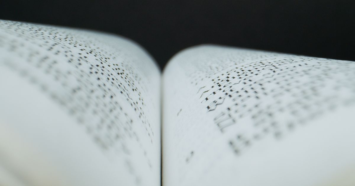 Abstract close-up of an open book s pages in soft focus, highlighting text pattern.