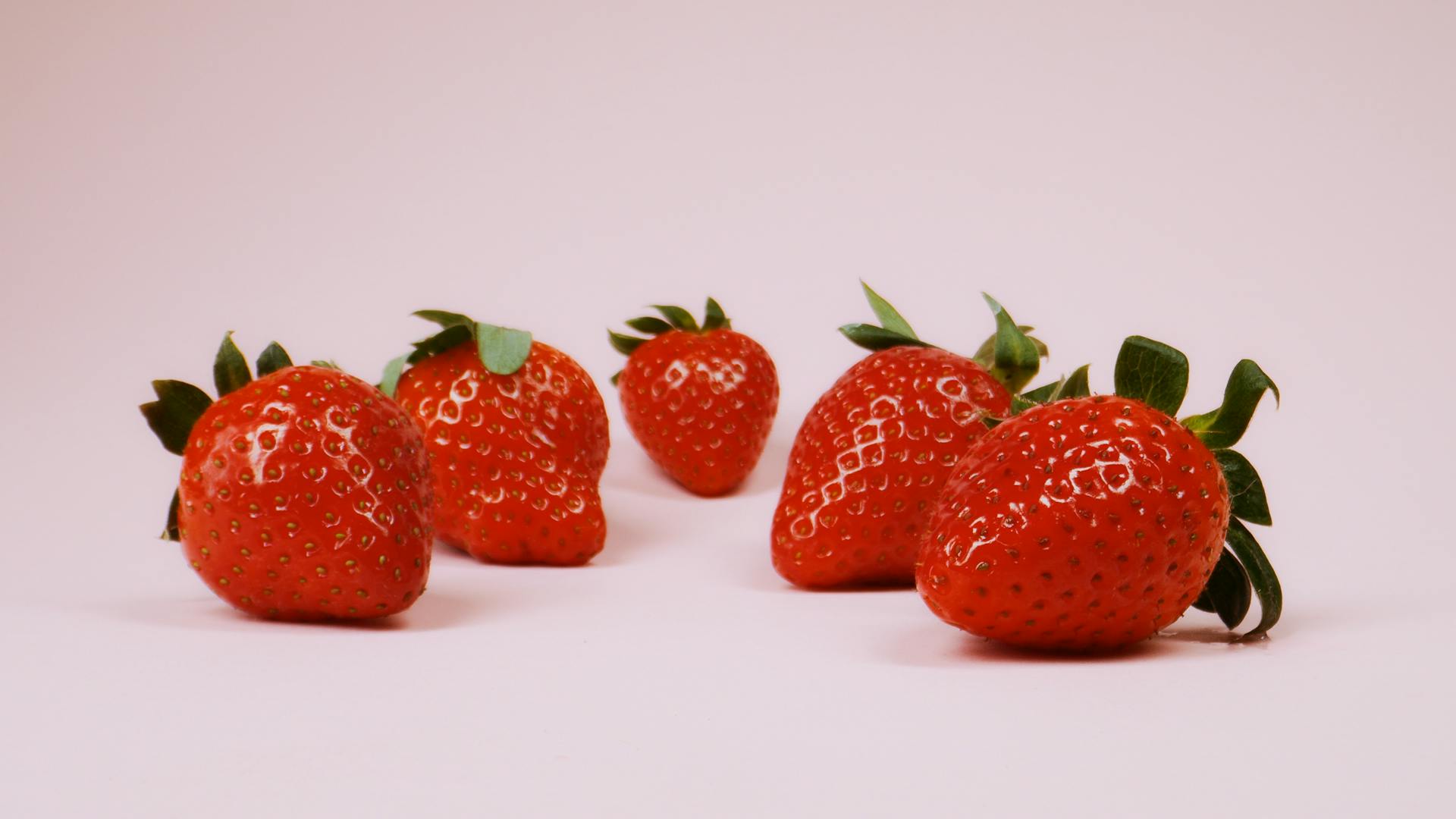 Close-up of fresh red strawberries on a soft pink background. Perfect for healthy eating concepts.