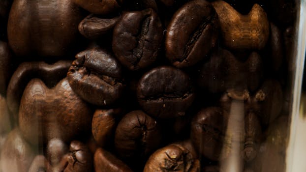 Detailed shot of aromatic roasted coffee beans in a jar, emphasizing texture.