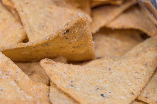 A macro shot of golden salted tortilla chips, showcasing texture and seasoning.
