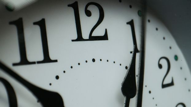 Macro photograph of a clock face showing numbers and minute markers.