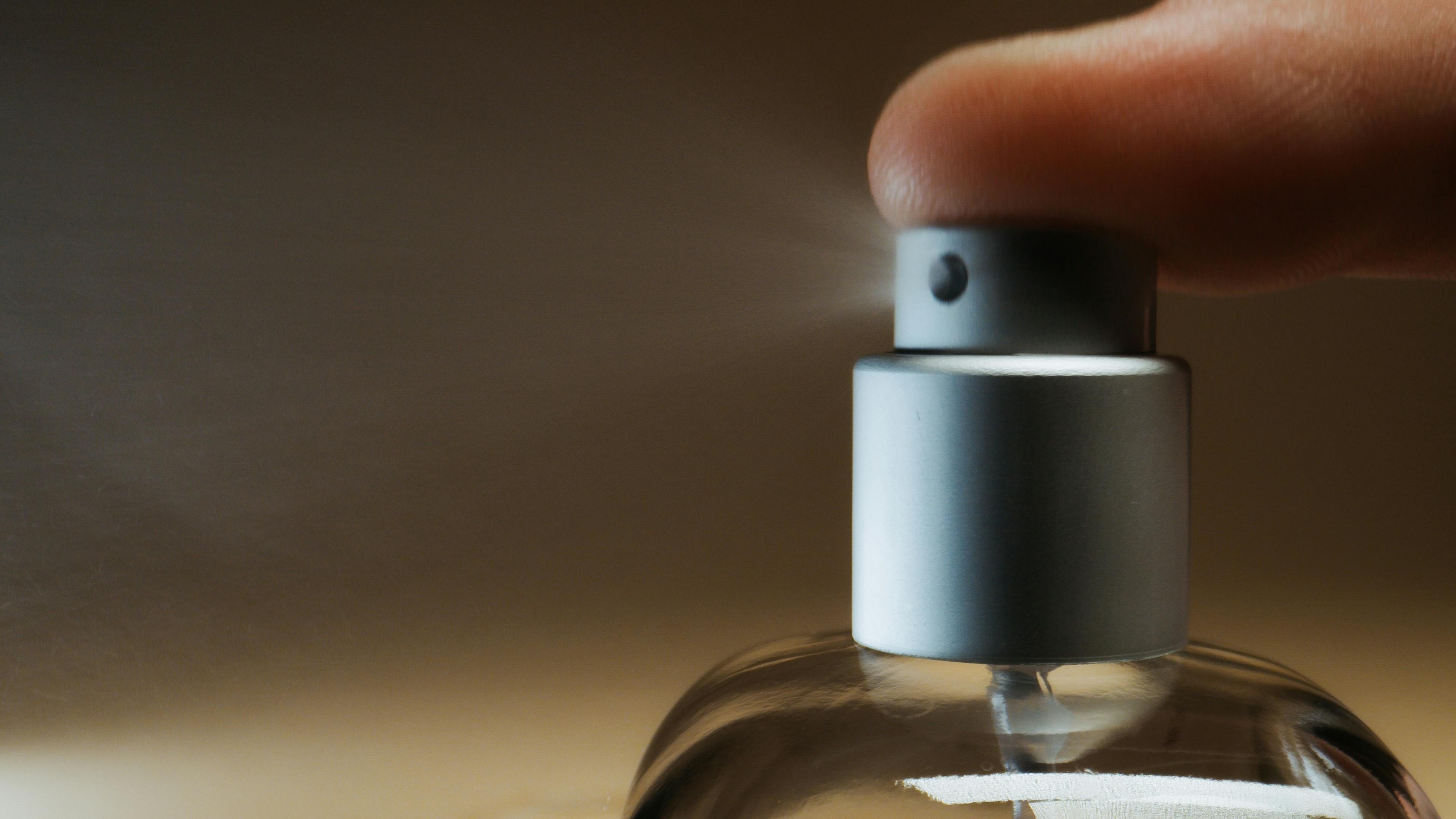 close up photograph of a person s finger using a spray