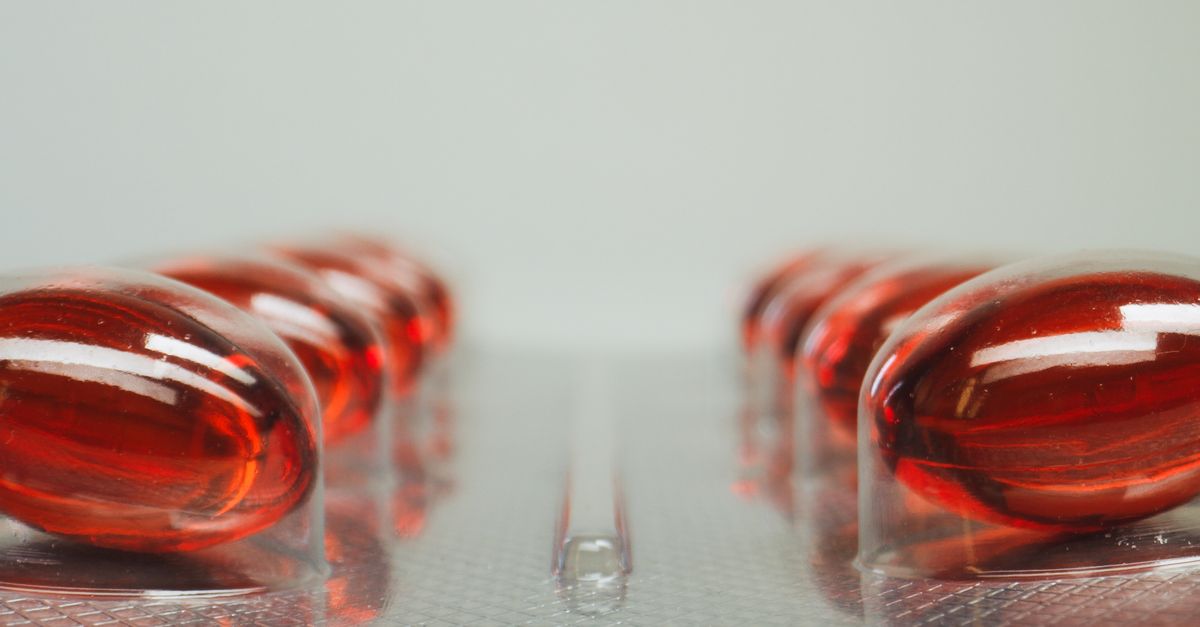 Macro shot of red capsules in a blister pack with selective focus on medicinal pills. - Evidence evidence guide for Vitamin B12: Methylcobalamin vs Cyanocobalamin and Who Needs to Supplement