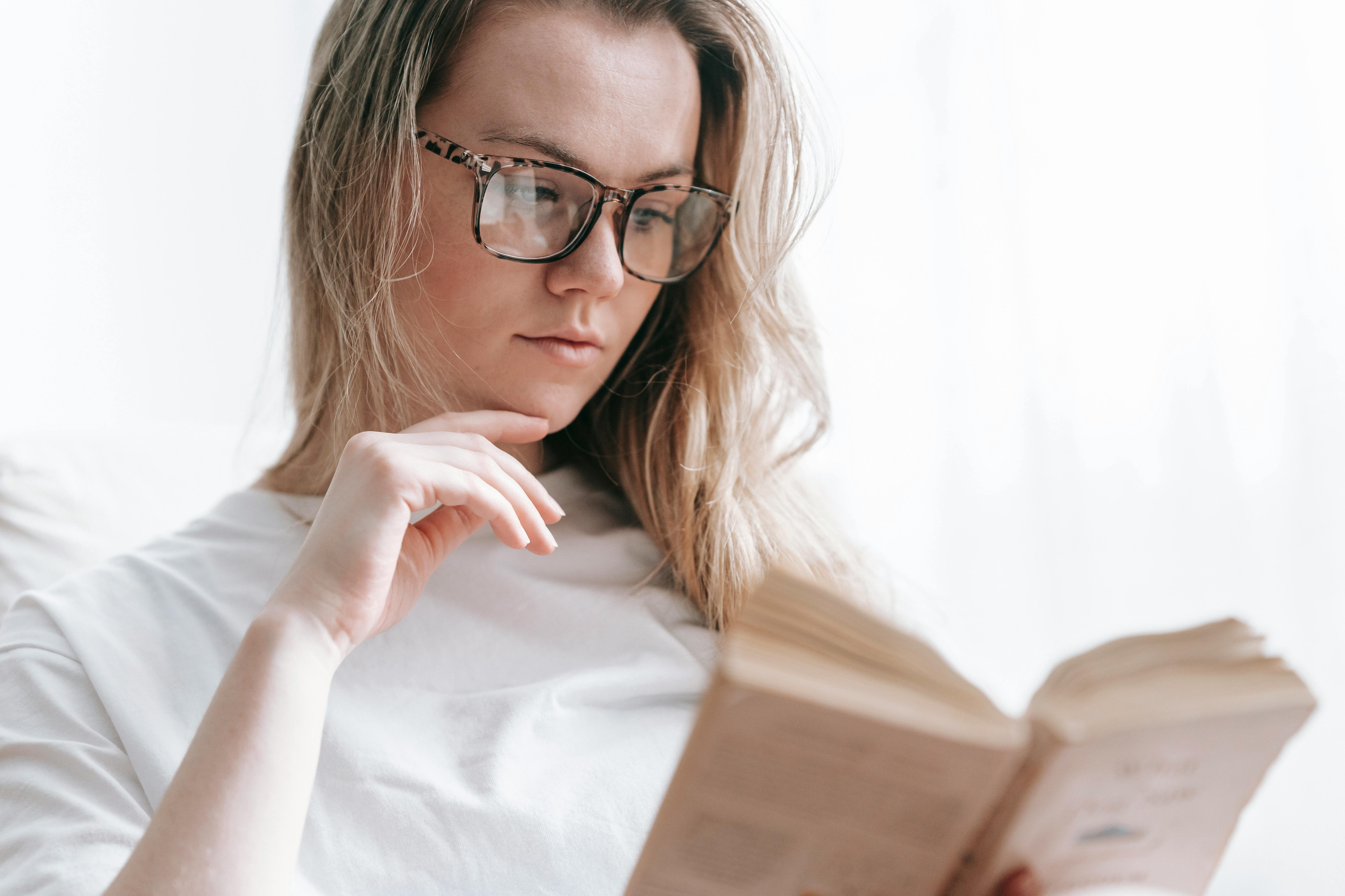 pensive woman reading interesting book at home