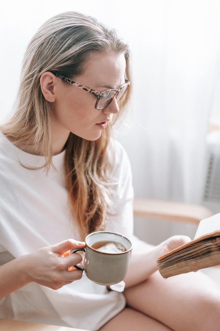 Woman With Tea Reading Retro Book At Home