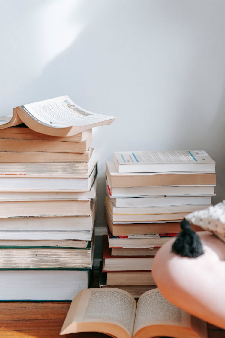 Crop Student On Floor With Piles Of Books At Home