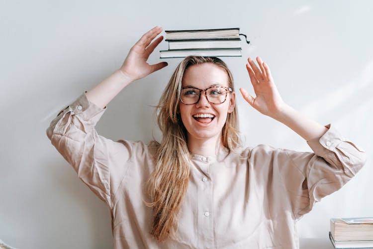 Happy Student With Heap Of Books On Head