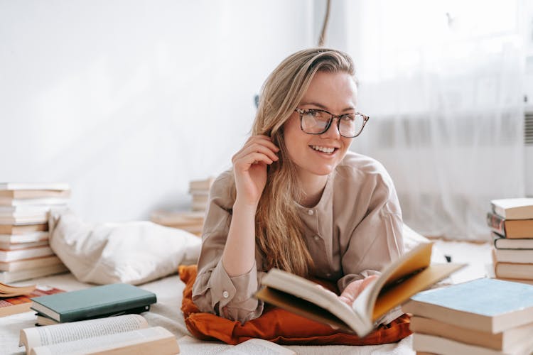 Smiling Student In Eyewear Among Books At Home