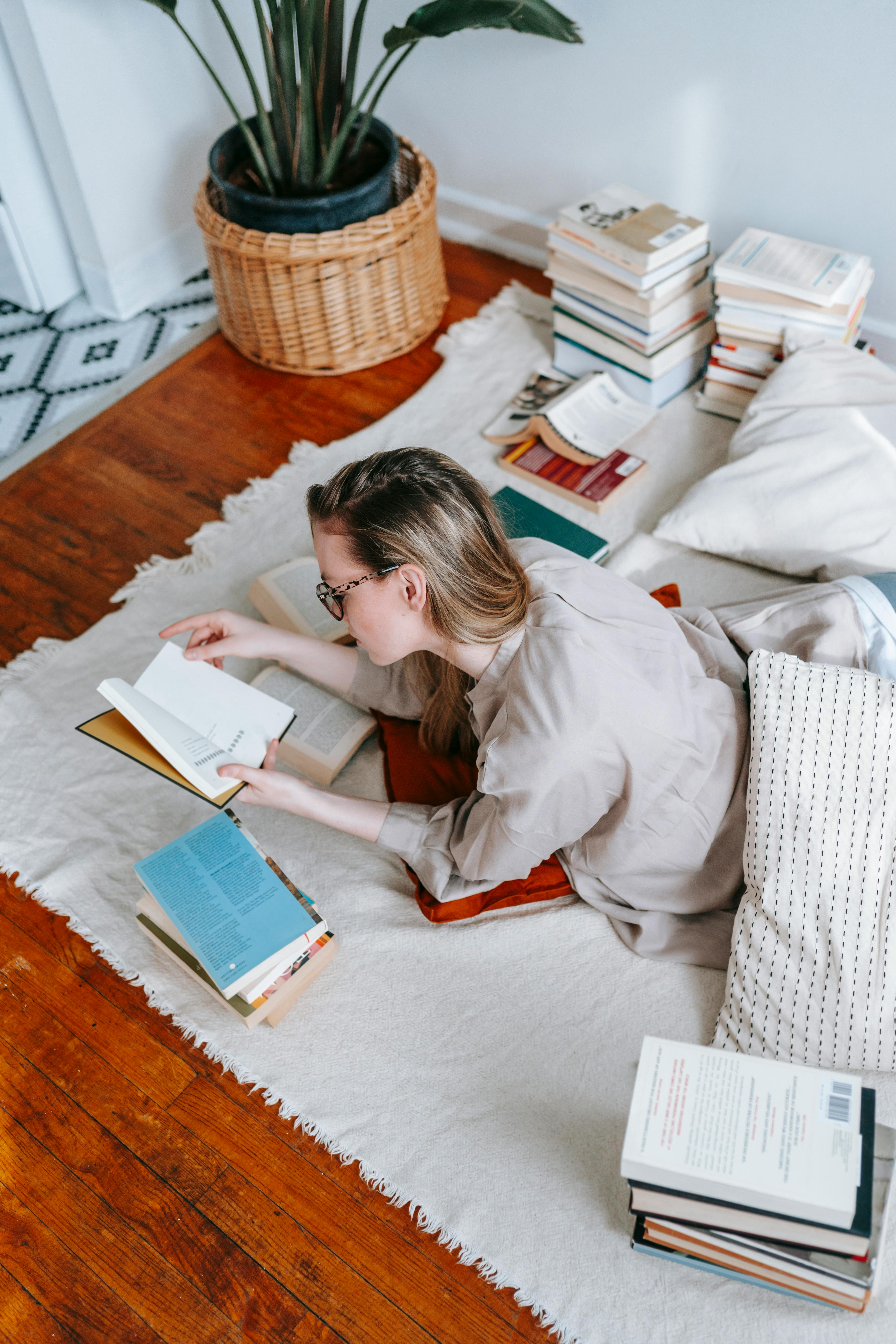 young woman reading different books for research