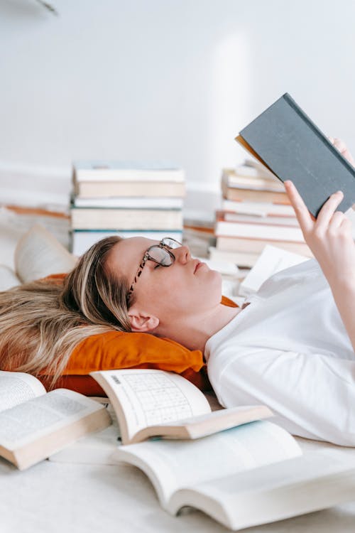 Serious woman reading novel on floor