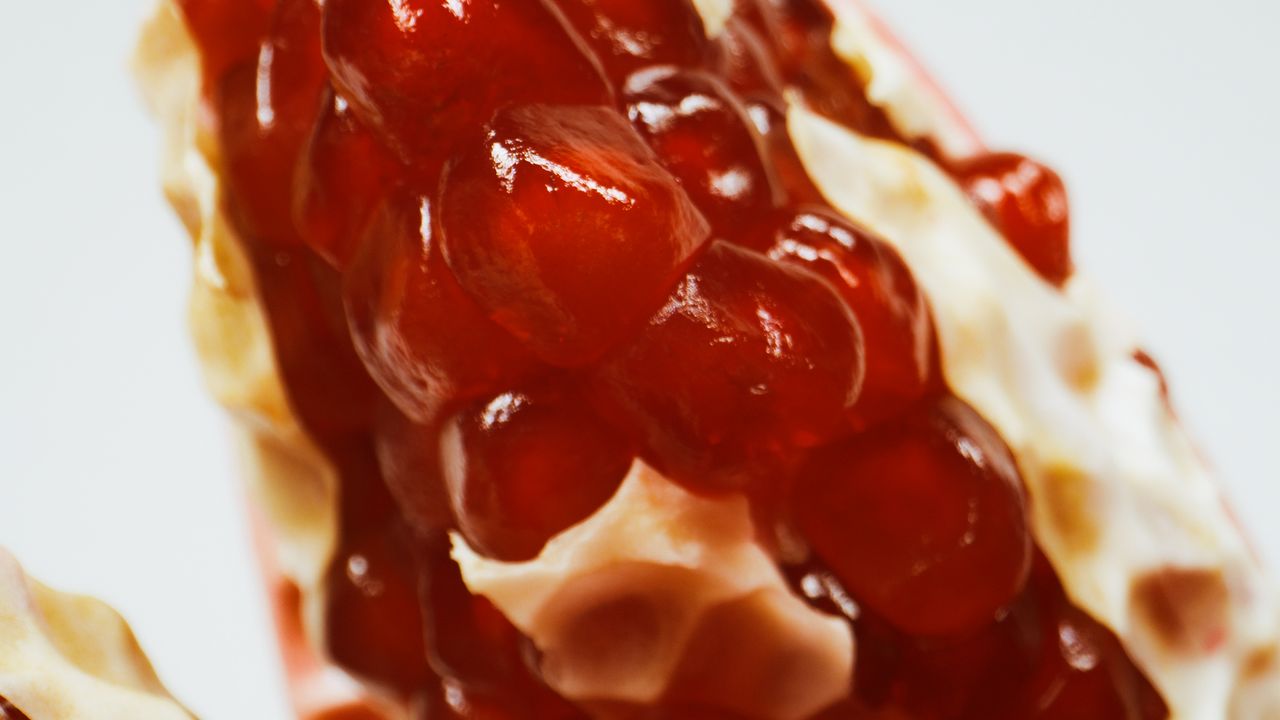macro shot of shiny red pomegranate seeds in natural lighting
