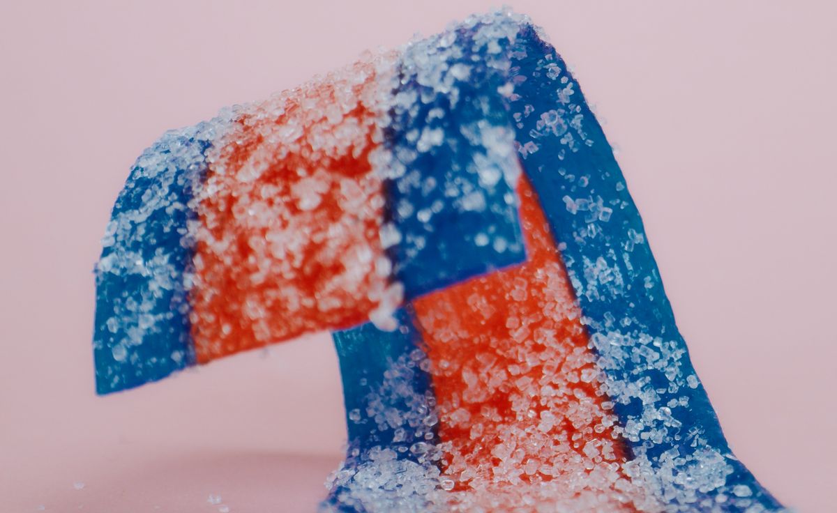 Bright and vibrant close-up of red and blue sour candy strips coated in sugar crystals.